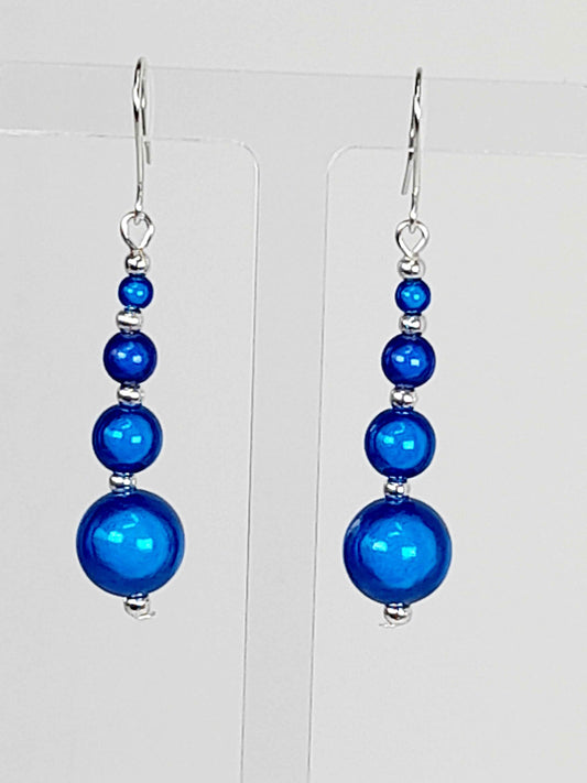 Bright Blue Miracle Bead Earrings On A White Background