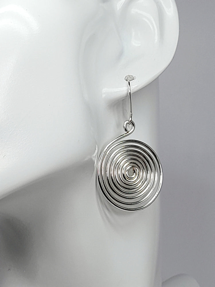 Large handmade spiral finished with a handmade silver plated ear wire hook shown on a white mannequin head