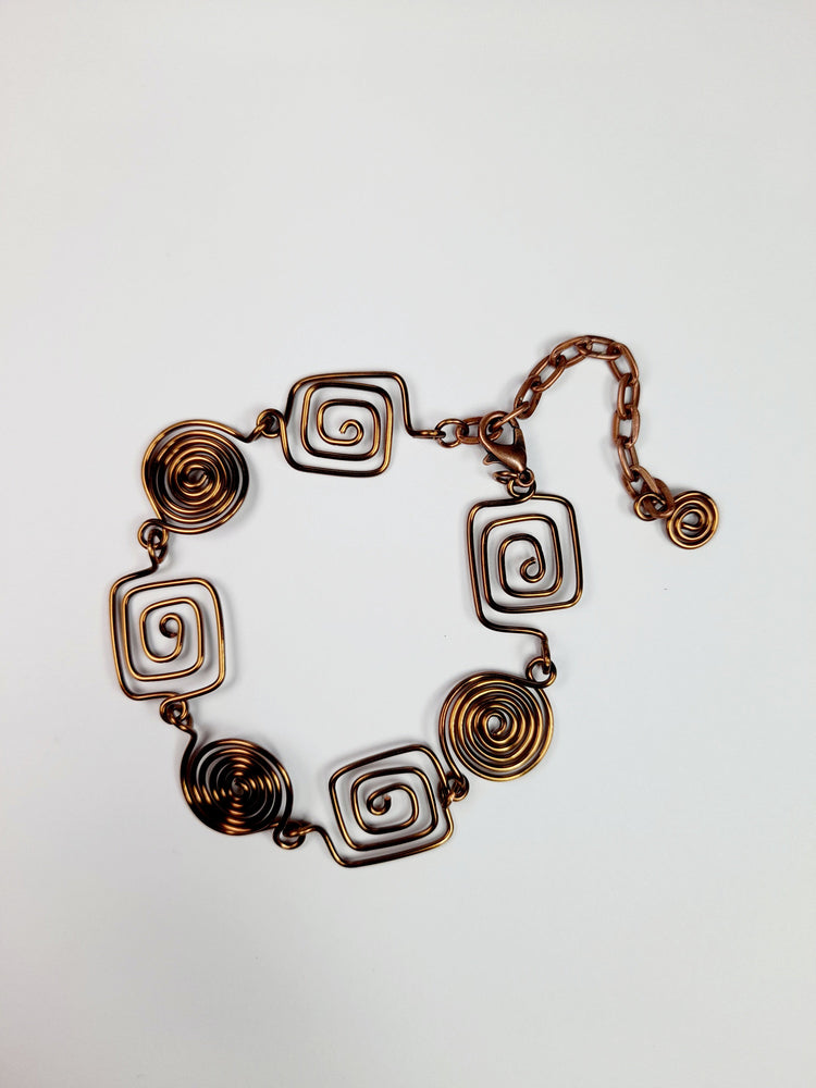 Bronze spiral bracelet made from four square and three round spirals, finished with a bronze plated lobster clasp and extension chain decorated with a tiny round spiral.