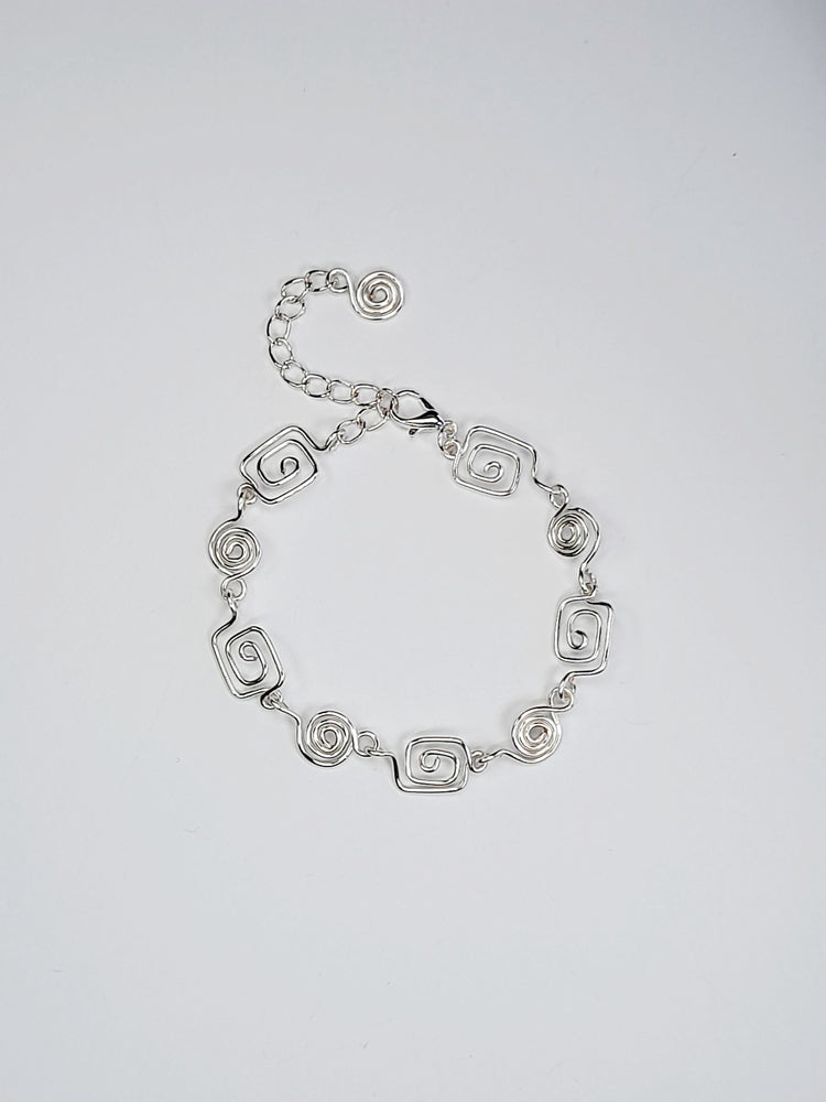 Silver spiral bracelet comprised of five tiny square spirals and four round ones   finished with a silver plated lobster clasp and extension chain 