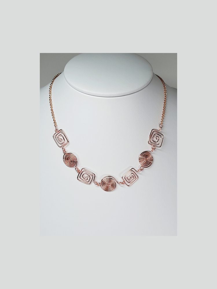 A rose gold and chain necklace shown on a white background.