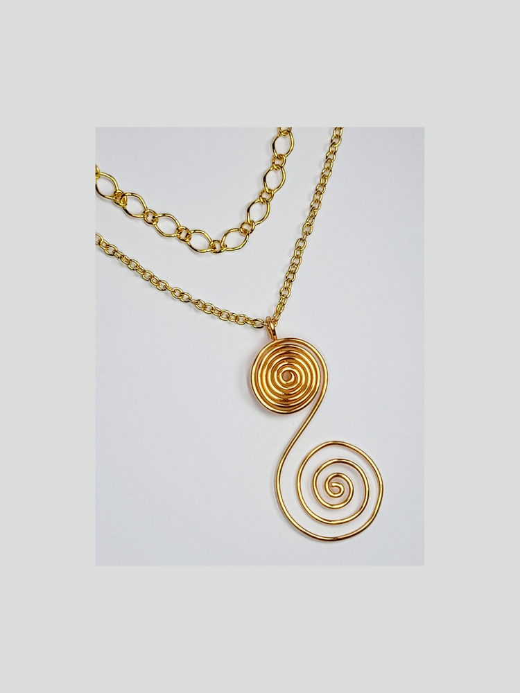 Multi chain gold necklace with gold plated "s" shaped spiral pendant.