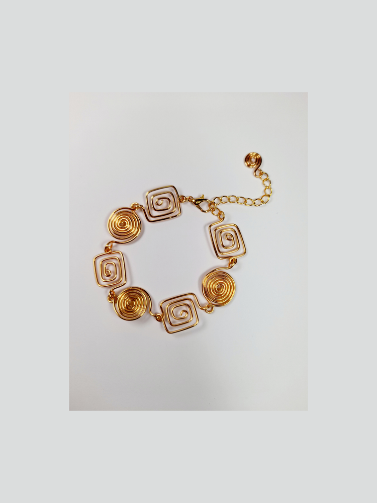 Gold spiral bracelet shown on a white background.