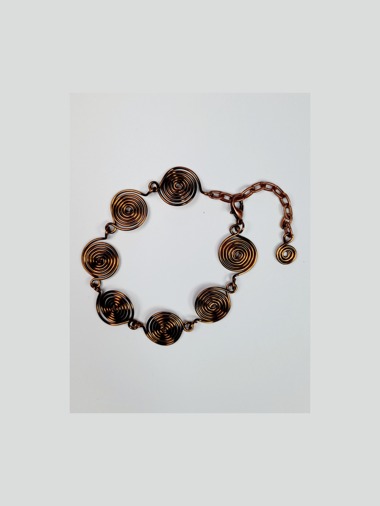 Bronze spiral bracelet shown on a white background.