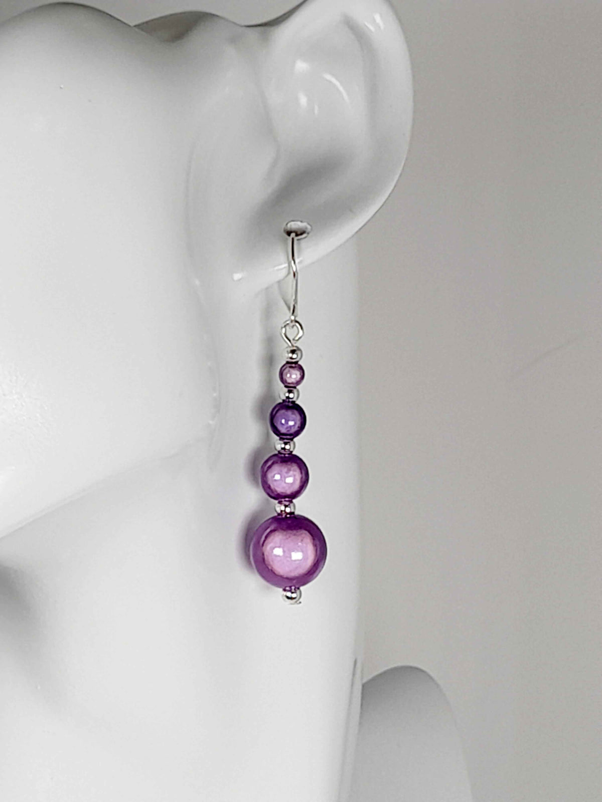 Lilac miracle bead earring displayed on a white head mannequin