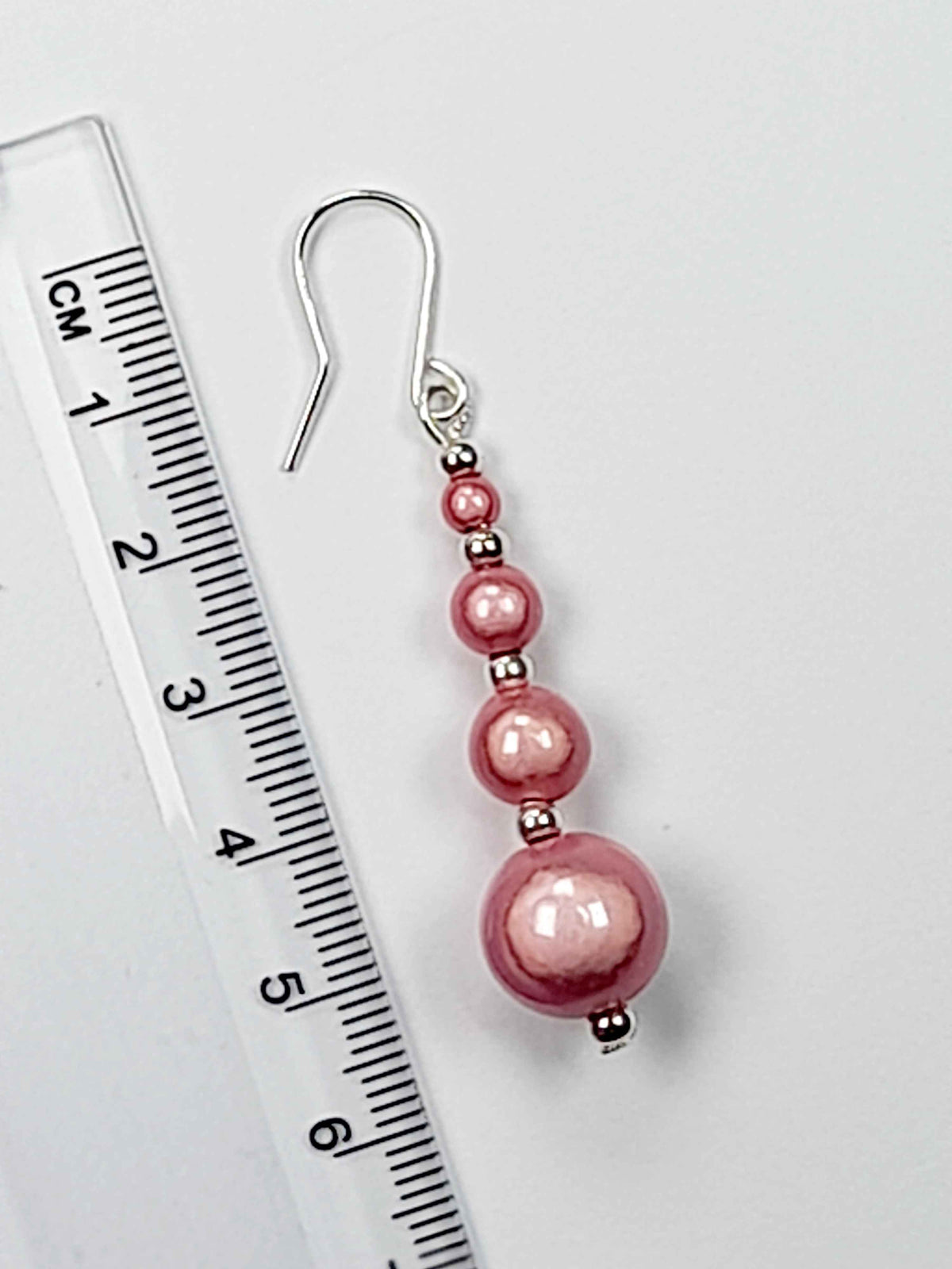 Pale pink miracle bead earring with ruler showing 6cm drop.
