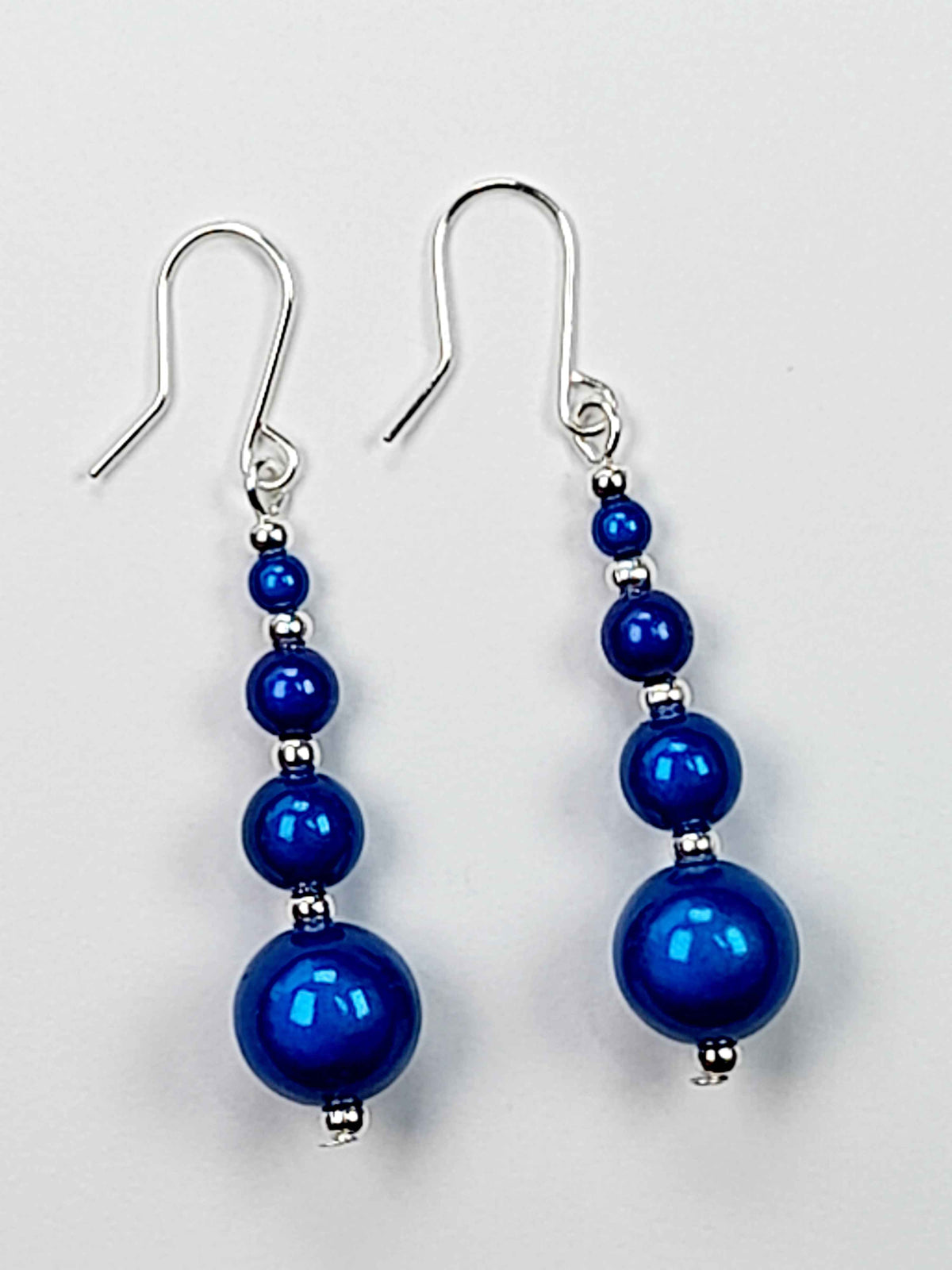 Bright Blue Miracle Bead Earrings On A White Background