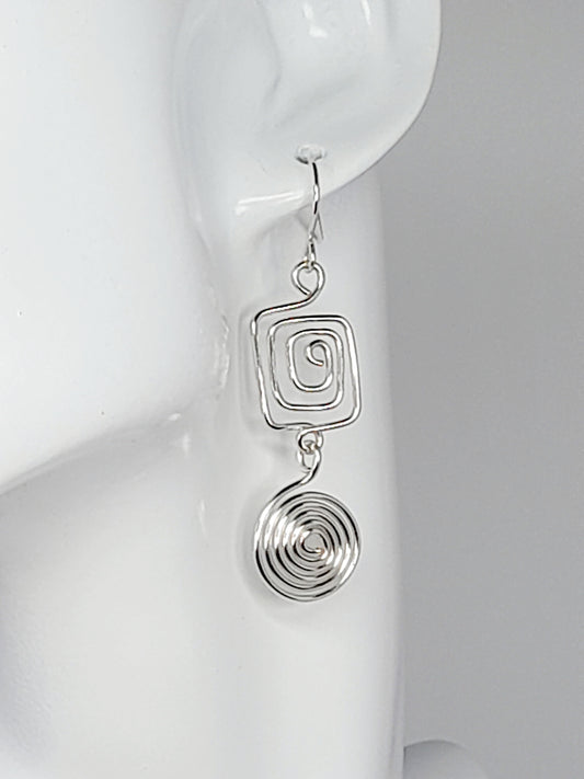 Handmade silver geometric double spiral drop earrings showing square top spiral and round dangling bottom spiral
